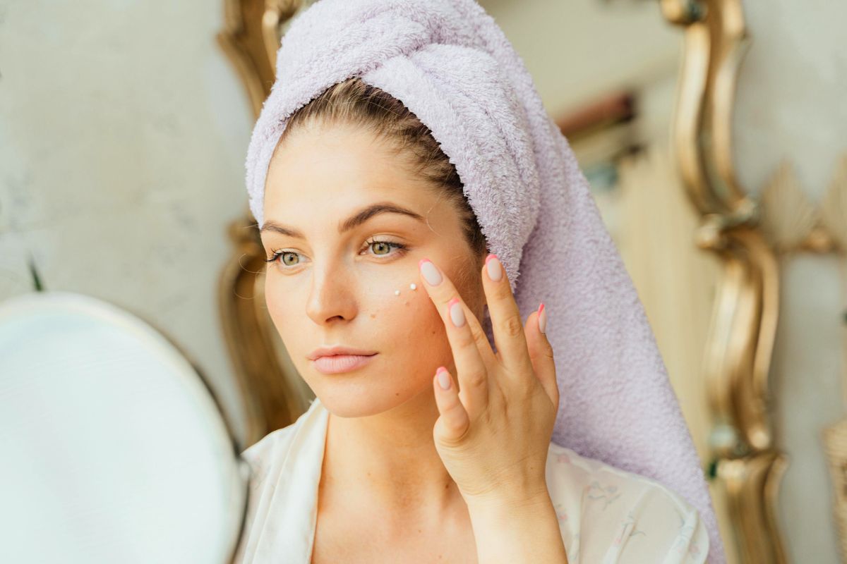A woman applies turmeric skincare to her face.