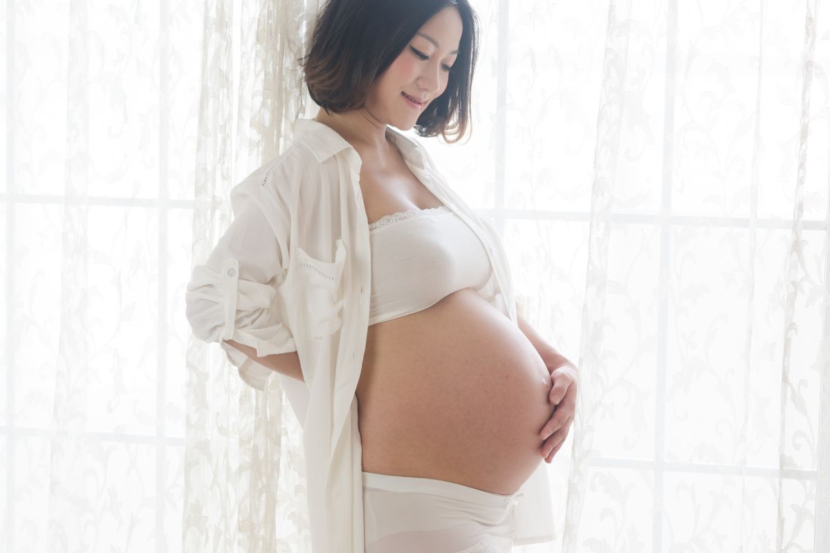 A pregnant woman holds her baby bump.