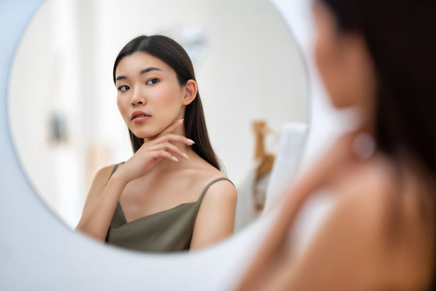 woman checking skin for discoloration or blemishes