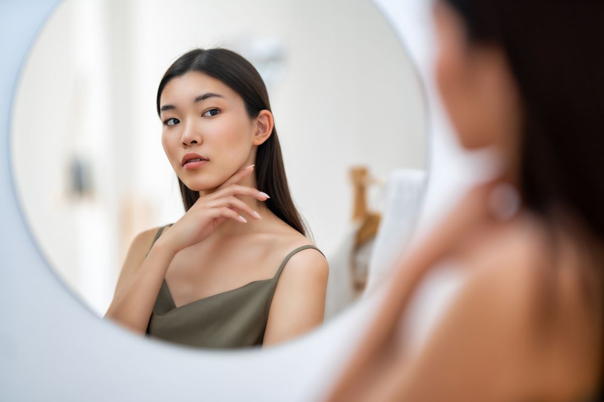 woman checking skin for discoloration or blemishes