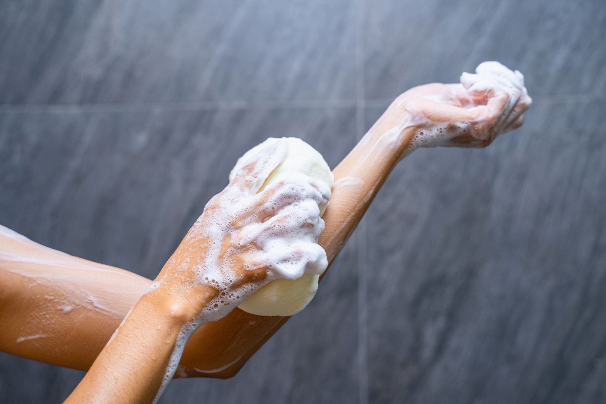 The woman uses body wash when she takes a shower.