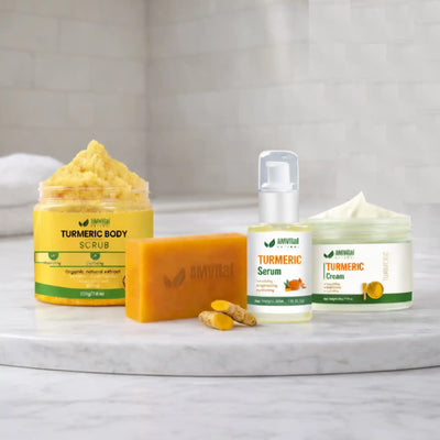 Collection of Amrita Ayurveda skincare products including scrub, soap, serum, and cream on a marble surface.
