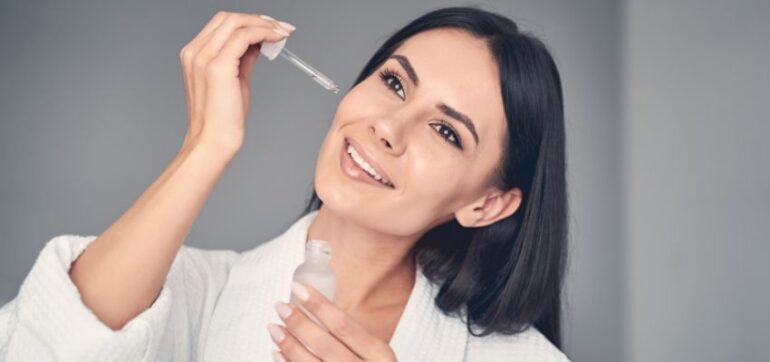 A woman uses hyaluronic acid serum.