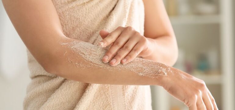 The woman applied body scrubs to her arm.