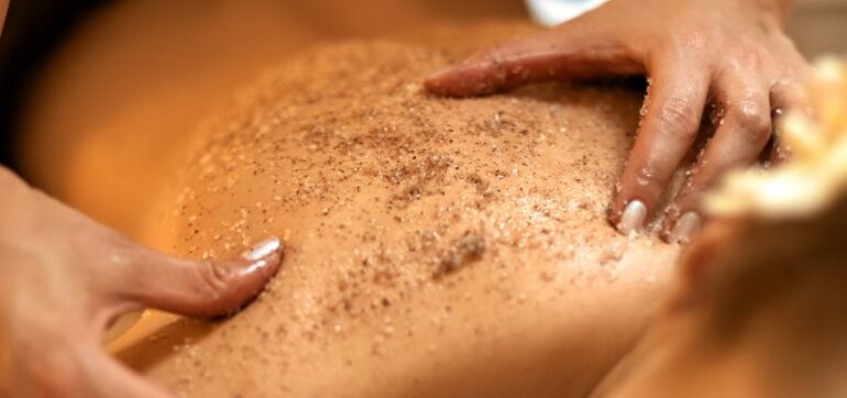 The woman uses a brown sugar body scrub to remove dead skin cells and deliver essential moisture for a healthy glow.