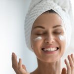 The woman is happy to use vegan skincare products.