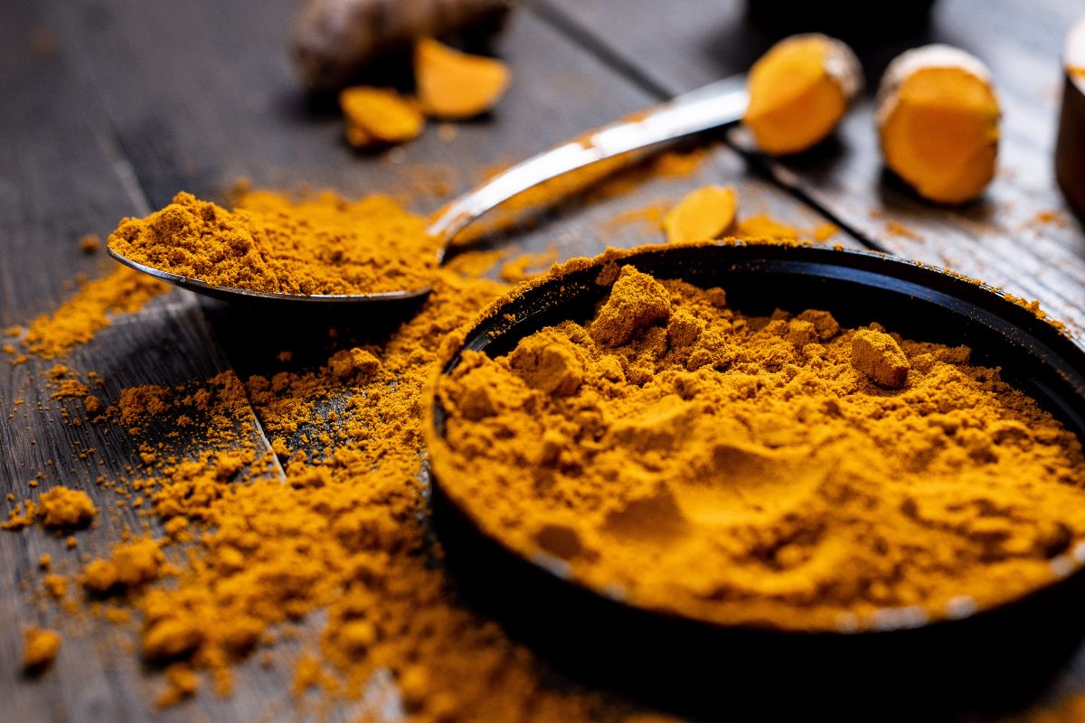 A bowl of turmeric spreads out on a table.