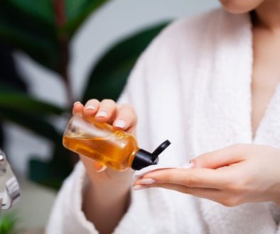 The woman applies turmeric toner to a cotton ball.