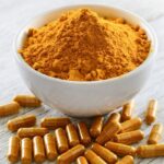 A bowl of turmeric and supplements.