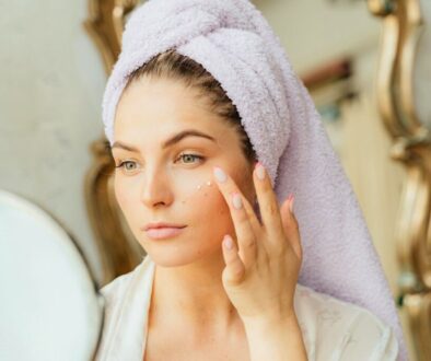 A woman applies turmeric skincare to her face.